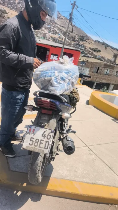 Repartidor junto a una motocicleta con paquete de separadores